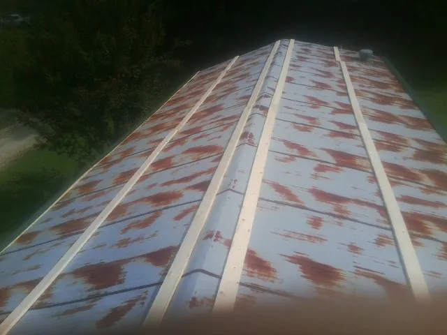 Rusted metal roof panels with new wood purlins before replacement — Storm Damage Roof Repair in Tipton by Roofing Brothers
